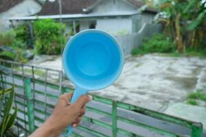 photo of blue water dipper in hand