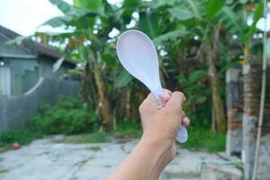 Photo of a white spoon held in hand