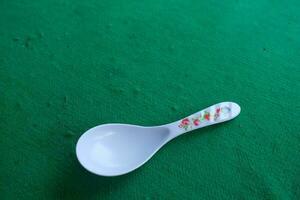 Photo of a white spoon with a green background