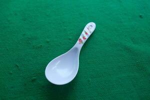 Photo of a white spoon with a green background