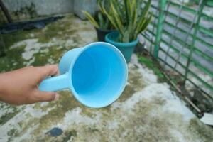 photo of blue water dipper in hand