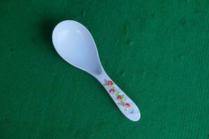 Photo of a white spoon with a green background