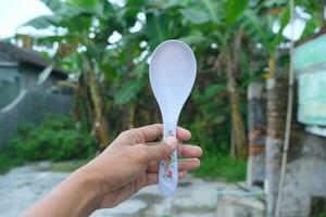 Photo of a white spoon held in hand