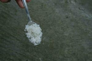 photo of rice on a spoon with hands