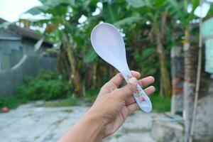 Photo of a white spoon held in hand