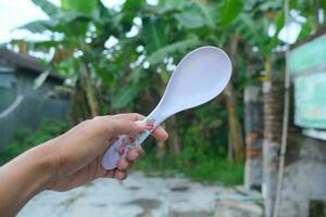 Photo of a white spoon held in hand