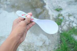 Photo of a white spoon held in hand