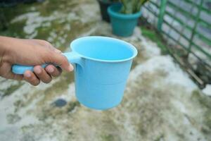 photo of blue water dipper in hand