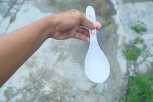 Photo of a white spoon held in hand