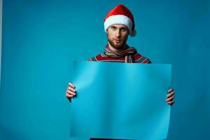 Cheerful man in New Year's clothes advertising copy space blue background photo