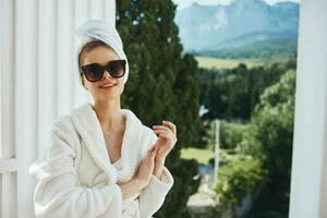 hermosa mujer en un blanco túnica en el balcón poco en verde naturaleza estilo de vida foto