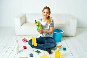mujer sentado en el piso con limpieza suministros limpieza Servicio tareas del hogar foto