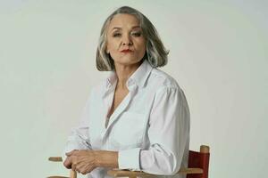 elderly woman stands near a chair lifestyle white shirt posing photo