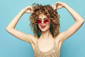 dulce mujer bailando en un azul fondo, Moda Gafas de sol foto