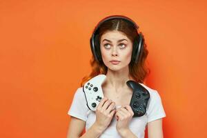 cheerful girl in a white t-shirt in headphones with a joystick in hands playing entertainment photo