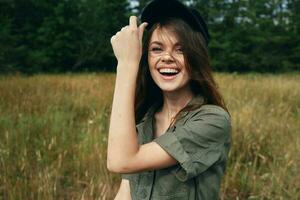 mujer en un prado en un camisa con un gorra en su cabeza y un hermosa sonrisa foto