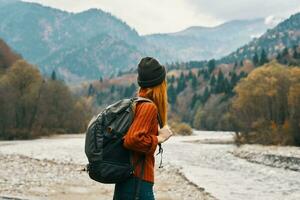 mujer caminante con un mochila descanso en el montañas en naturaleza cerca el río foto