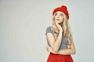 bonito mujer en un a rayas camiseta rojo sombrero posando estudio foto