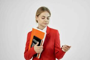 Businesswoman in a red jacket with documents in hand light background photo