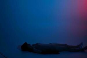 woman lying on the floor neon blue light photo