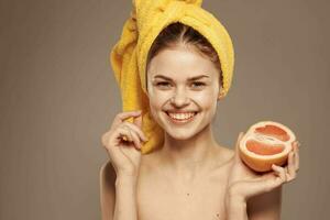 alegre mujer con amarillo toalla en su cabeza pomelo claro piel beige antecedentes foto