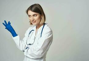 médico en azul médico guantes gesticulando con su manos en un gris antecedentes recortado ver foto