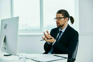 man in a suit work in front of a computer documents executive photo