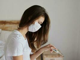 woman sitting on the bed in the bedroom without a thermometer in her hands photo