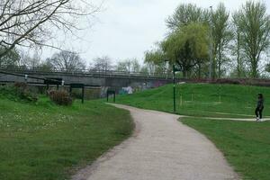 Low Angle View of Willen Lake Park with Local and Tourist Public Enjoying the Beauty of Lake and Park by Walking Around with Their Families. Footage Was Captured on 09-April-2023 at Milton Keynes UK photo