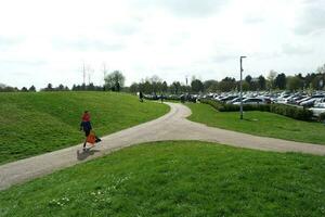 Low Angle View of Willen Lake Park with Local and Tourist Public Enjoying the Beauty of Lake and Park by Walking Around with Their Families. Footage Was Captured on 09-April-2023 at Milton Keynes UK photo