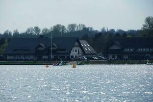 Low Angle View of Willen Lake Park with Local and Tourist Public Enjoying the Beauty of Lake and Park by Walking Around with Their Families. Footage Was Captured on 09-April-2023 at Milton Keynes UK photo