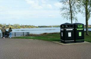 Low Angle View of Willen Lake Park with Local and Tourist Public Enjoying the Beauty of Lake and Park by Walking Around with Their Families. Footage Was Captured on 09-April-2023 at Milton Keynes UK photo