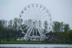 Low Angle View of Willen Lake Park with Local and Tourist Public Enjoying the Beauty of Lake and Park by Walking Around with Their Families. Footage Was Captured on 09-April-2023 at Milton Keynes UK photo