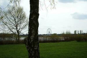 Low Angle View of Willen Lake Park with Local and Tourist Public Enjoying the Beauty of Lake and Park by Walking Around with Their Families. Footage Was Captured on 09-April-2023 at Milton Keynes UK photo