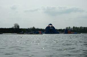 Low Angle View of Willen Lake Park with Local and Tourist Public Enjoying the Beauty of Lake and Park by Walking Around with Their Families. Footage Was Captured on 09-April-2023 at Milton Keynes UK photo