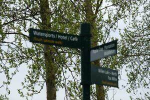 Low Angle View of Willen Lake Park with Local and Tourist Public Enjoying the Beauty of Lake and Park by Walking Around with Their Families. Footage Was Captured on 09-April-2023 at Milton Keynes UK photo