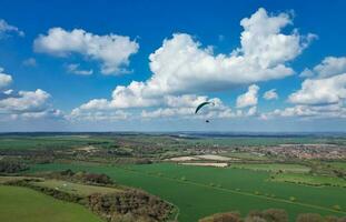 aéreo ver de británico campo y parapentes mientras ellos son volador alto en el cielo. drones cámara imágenes. foto