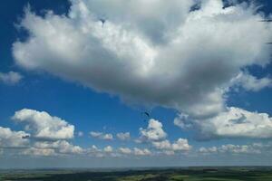 aéreo ver de británico campo y parapentes mientras ellos son volador alto en el cielo. drones cámara imágenes. foto