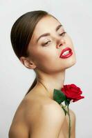 Woman with bare shoulders With a rose in his hands red lips photo