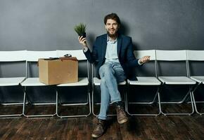 Man sitting on white chair waiting for lighting box job search depression photo