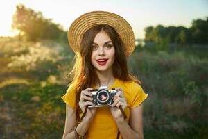 bonito mujer participación cámara en manos naturaleza Fresco aire estilo de vida foto