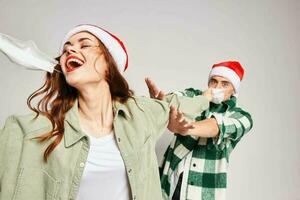 Man and woman in Christmas caps medical mask emotions fun together New Year photo