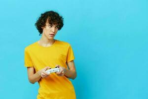 man plays with joystick in yellow t-shirts Lifestyle entertainment photo