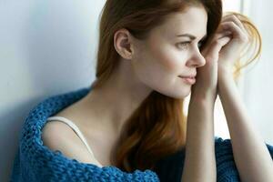 woman sitting on the windowsill with a blue plaid morning photo