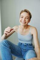 Young woman with short haircut hair having fun at home on the couch smile and happiness, vacation at home, natural posing without filters, free copy space photo