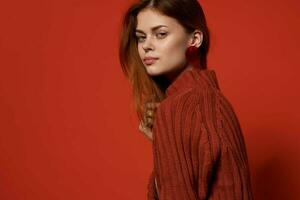 alegre mujer en rojo suéter pendientes encanto productos cosméticos modelo foto