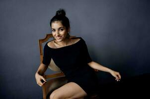 brunette earrings jewelry posing near the chair black dress dark background photo