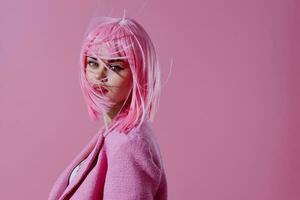 retrato de un encantador dama en un rosado chaqueta de sport rosado peluca recortado ver rosado antecedentes inalterado foto