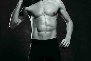 sporty man naked torso inflated body posing dark background photo