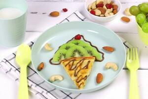 Ice cream. Waffles with kiwi and nuts for children's breakfast. A creative and healthy idea for a fun kids dessert or breakfast photo